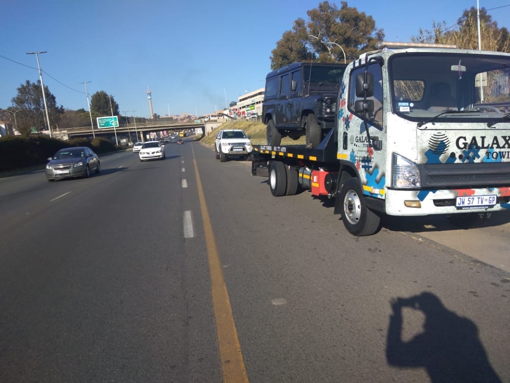 Two Galaxy Towing trucks loaded with sports cars in Johannesburg